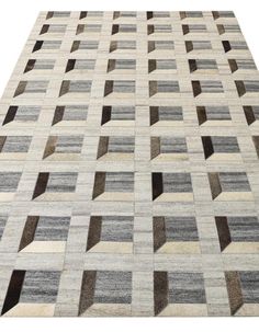 an area rug with squares and rectangles in grey, beige and black colors