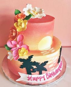 a birthday cake decorated with flowers and palm trees