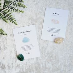 two cards sitting next to each other on top of a table with plants in the background