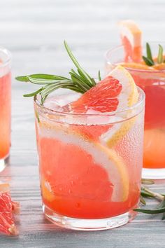 two glasses filled with grapefruit and rosemary garnish