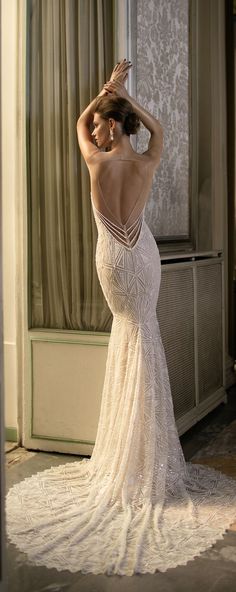 a woman in a wedding dress is looking into the mirror and touching her hair with her hand