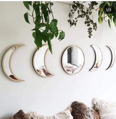 three mirrors are hanging on the wall above a couch with pillows and throw pillows in front of them