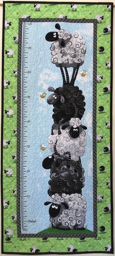 a quilted wall hanging with sheep and measuring tape on it's sides, in front of a green background