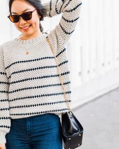 a woman wearing sunglasses and a sweater