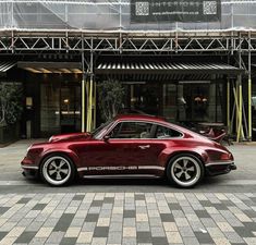 a red porsche parked in front of a building