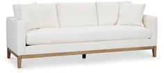 a white couch with wooden legs and pillows on it's back end, against a white background