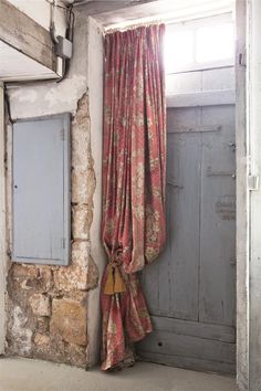 an open window with curtains hanging from it's side