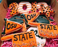 decorated cookies in a box with the word osu state spelled out on them,