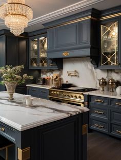 an elegant kitchen with marble counter tops and black cabinets, chandelier above the stove