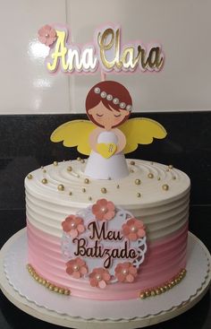 a birthday cake decorated with an angel and name on the top, sitting on a table