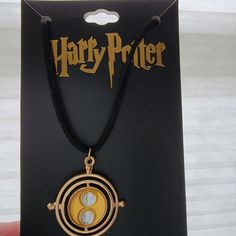 a harry potter necklace is shown in the box with it's logo on it