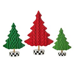 three small christmas trees are in the shape of knitted trees with checkers on them