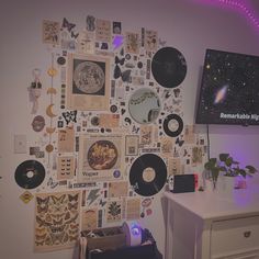 there is a wall with many different records on it and a television in the corner