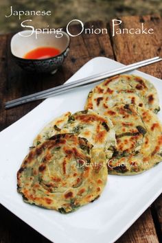 japanese spring onion pancakes on a white plate with chopsticks next to the dish