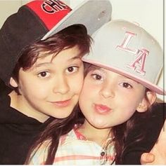 two young children wearing hats and posing for the camera