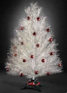 a white christmas tree with red ornaments on it