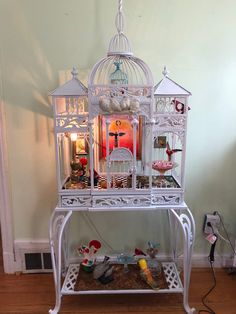 a white birdcage filled with lots of toys