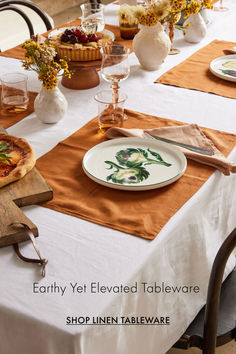 the table is set with plates, glasses and pizzas on it for an earthy yet elevated tableware