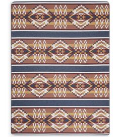 a brown and blue rug with an abstract design on the bottom, in front of a white background