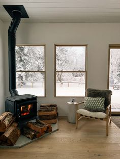 a living room filled with furniture and a fire place in front of two large windows