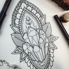 a pen and ink drawing of a diamond in the middle of an intricate design on paper