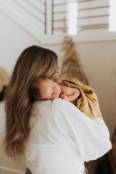 a woman holding a baby wrapped in a blanket