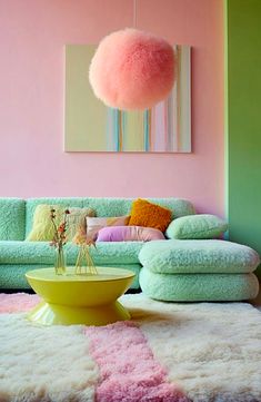 a living room filled with furniture and a large pink pom - pom ball hanging from the ceiling