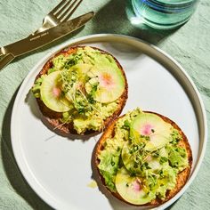 two pieces of bread with avocado on them and a fork next to it