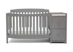 a gray crib with two drawers and a white sheet on the bottom half of it