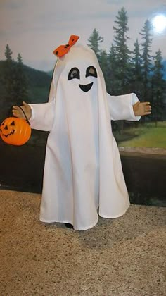 a white ghost with a pumpkin in his hand