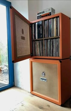 an orange cabinet with some records on it