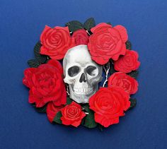 a skull surrounded by red roses on a blue background