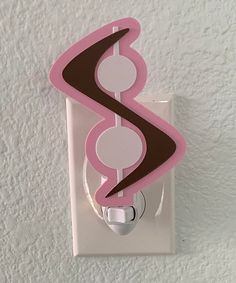 a pink and brown swirl light switch cover on a white wall in a room with white walls