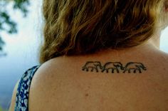 the back of a woman's shoulder with elephants on it