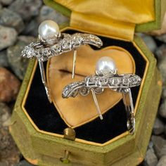 These awesome circa 1950s pierced earrings are each accented with one (1), post set, cultured saltwater Akoya pearl and thirty-nine (39), prong/bead set, old European/brilliant/single cut diamonds. The earrings measure 29.6mm X 25.7mm. The earrings are finished with hinged backs. Vintage Diamond Clip-on Earrings, Antique Drop Pearl Earrings For Formal Occasions, Antique Pearl Drop Earrings For Formal Occasions, Antique Clip-on Pearl Earrings For Wedding, Vintage White Gold Pearl Earrings For Anniversary, Vintage Hallmarked Earrings For Evening, Victorian Style Pearl Earrings For Evening, Heirloom Evening Jewelry With Matching Earrings, Vintage Pierced Diamond Earrings