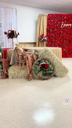 a room decorated for christmas with red and white decorations on the walls, hay bales and wreaths