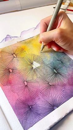 a person is drawing with colored pencils on paper