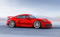 a red sports car parked in front of mountains