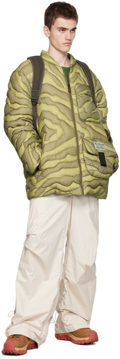 DIST-certified down-filled quilted nylon ripstop jacket. Graphic pattern throughout. · Stand collar · Zip closure · Flap pockets and seam pockets · Logo patches at front · Text embroidered at back · Nylon longue saison lining Part of the Moncler x Salehe Bembury collection. Supplier color: Green Fill: 90% goose down, 10% goose feather. Green Puffer Jacket With Pockets For Outdoors, Green Quilted Jacket With Pockets For Outdoor, Quilted Nylon Long-sleeved Parka, Quilted Nylon Parka With Long Sleeves, Green Down Puffer Jacket With Pockets, Outdoor Duck Down Puffer Jacket With Pockets, Long Sleeve Nylon Puffer Jacket With Pockets, Outdoor Nylon Quilted Jacket With Pockets, Outdoor Quilted Nylon Jacket With Pockets