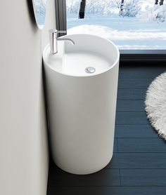 a white sink sitting next to a window in a room with snow on the ground