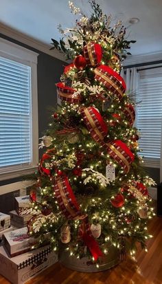 a christmas tree decorated with red and gold ribbons