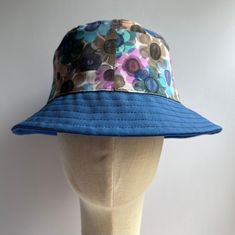 Multicolor blues Daisy Beach/ Rain Hat, packable hat, Crushable hat, bucket Hat,  Fabric Hat,  Travel Hat Hi-Welcome to my shop!  I created this daisy pattern from one of my original water color paintings.   This hat is perfect for the beach- sun, rain or wearing around town.  Medium weight canvas makes a substantial hat. Keeps it's shape even if you throw it in your pocket. Sun and rain protection that you can put in your pocket or bag. Pack it, crush it, it's keep its form good as new  A little about me, the maker, Anne: 🎨I have a  BFA in Textiles from RISD. I have been working as a Broadway / theatrical milliner for over 25 years making hats for Broadway, print and TV.  I started my NYC career working in fashion for Betsey Johnson, Anna Sui, Donna Karan, and JLo by a Jennifer Lopez. Ma Beach Rain, The Cher Show, Bob Chapeau, Hat Fabric, Best Costume Design, Canvas Hat, Packable Hat, Travel Hat, Rain Protection