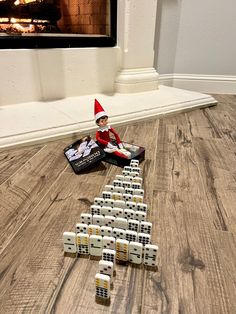 an elf is sitting on the floor next to dominos