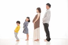 a group of people standing next to each other in front of a white background,