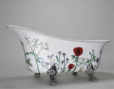 an old fashioned bathtub with flowers painted on the side and metal faucet legs