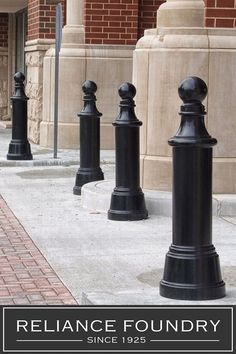 the black poles are lined up on the sidewalk