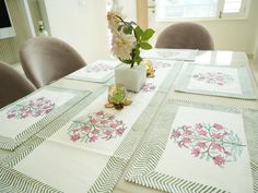 the table is set with placemats and flowers in vase on top of them