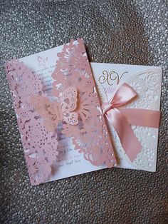 two cards with pink and white paper on them, one has a bow at the top