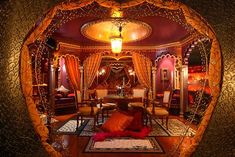 an elaborately decorated living room with gold and red accents, is seen through a fish eye lens