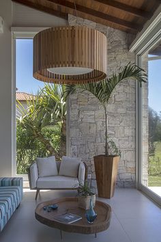 a living room filled with furniture next to a large glass window covered in greenery